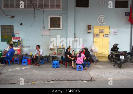 Juli, 2015 - Ho Chi Minh, Vietnam: Menschen sitzen auf kleinen Stühlen draußen in Straßencafé entlang der Straße. Stockfoto