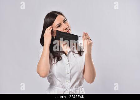 Die junge Frau trägt eine schwarze Gesichtsmaske Stockfoto
