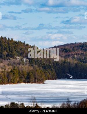 Ein Blick aus der Höhe auf Carson Lake, Ontario und die umliegenden Hügel. Die Oberfläche des Wassers ist im Spätwinter noch gefroren. Stockfoto