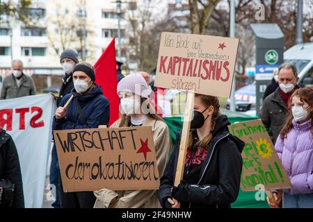 Demonstrantinnen halten Schilder für eine Demokratisierung der Wirtschaft und gegen den Kapitalismus. Hunderte Menschen sammeln sich am 19.3.2021 in München, um die Politik aufzufordern, sich an das Pariser Klimaabkommen zu halten. - Hunderte nahmen an einer Demonstration am 19 2021. März in München Teil, um sich an die Politiker zu erinnern, sich an das Pariser Abkommen zu halten. (Foto: Alexander Pohl/Sipa USA) Quelle: SIPA USA/Alamy Live News Stockfoto