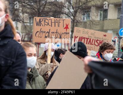 Demonstrantinnen halten Schilder für eine Demokratisierung der Wirtschaft und gegen den Kapitalismus. Hunderte Menschen sammeln sich am 19.3.2021 in München, um die Politik aufzufordern, sich an das Pariser Klimaabkommen zu halten. - Hunderte nahmen an einer Demonstration am 19 2021. März in München Teil, um sich an die Politiker zu erinnern, sich an das Pariser Abkommen zu halten. (Foto: Alexander Pohl/Sipa USA) Quelle: SIPA USA/Alamy Live News Stockfoto