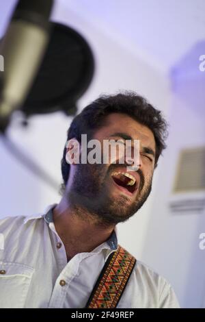Ein professioneller leidenschaftlicher Musiker mit E-Gitarre, der begeistert singt Und Aufnahmen im Studio Stockfoto