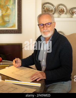 Älterer Mann, der zu Hause Pläne zeichnet Stockfoto