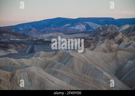 Zabriskie Punkt bei Sonnenuntergang, mit einer leeren Straße in der Ferne Stockfoto
