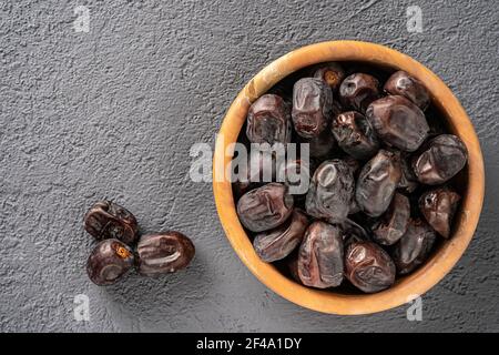 Datteln frisches Obst auf einem Holzteller, Draufsicht. Leerzeichen für den Text. Stockfoto