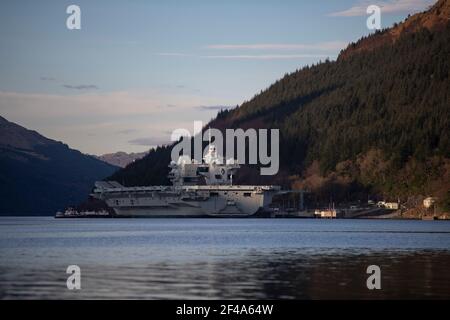 Finnart, Loch Long, Schottland, Großbritannien. März 2021, 19th. IM BILD: HMS Queen Elizabeth bei Nacht mit Reflexionen auf dem Wasser vor Loch Long. HMS Queen Elizabeth ist das größte und fortschrittlichste Kriegsschiff, das jemals für die Royal Navy gebaut wurde. Die Aircraft Carrier liegt derzeit an der Seite des Long Loch in Glenmallan und übernimmt Treibstoff, Munition und andere Vorräte, bevor die Marineübungen, die Teil der britischen Carrier Strike Group 2021 sind, durchgeführt werden. Das Schiff soll am Sonntag abreisen. Quelle: Colin Fisher/Alamy Live News Stockfoto