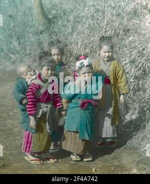 Japan. Vier japanische Mädchen mit Kleinkindern auf dem Rücken auf einem Spaziergang Stockfoto