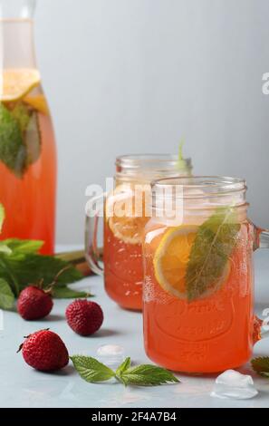 Limonade oder Cocktail Rhabarber, Erdbeere, Minze, Zitrone und Eis auf hellblauem Hintergrund. Vertikales Format Stockfoto