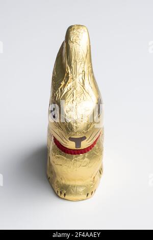 Schokoladen-Osterhase in goldene Folie auf weißem Hintergrund isoliert gewickelt. Stockfoto