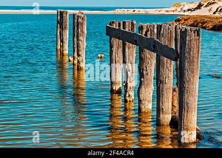 Überreste eines alten verfallenden Pier im Meer mit Strand Darüber hinaus Stockfoto