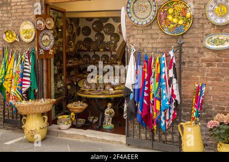 Siena, Italien. Ladenfront mit dekorativen italienischen Töpferwaren und kontrastierten Flaggen. (Nur Für Redaktionelle Zwecke) Stockfoto