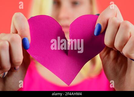 Gebrochenes Herz. Frau zerreißt Herz in der Mitte. Scheidung, Trennung, Trennung. Beziehungsproblem. Beziehungsbruch. Stockfoto