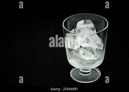 Nahaufnahme Glas voller Eis auf schwarzem Hintergrund Stockfoto