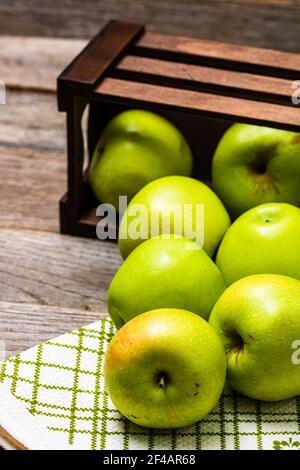 Eine hölzerne Kiste mit reifen grünen Äpfeln auf einem hölzernen Tabelle Stockfoto