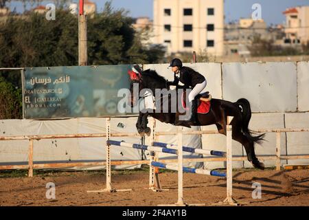 Gaza-Stadt. März 2021, 19th. Ein palästinensisches Mädchen reitet auf einem Pferd während eines Reitwettbewerbs, der von der Palästinensischen Pferdeföderation im Aljawad Equestrian Club in Gaza City organisiert wird, 19. März 2021. Kredit: Rizek Abdeljawad/Xinhua/Alamy Live Nachrichten Stockfoto