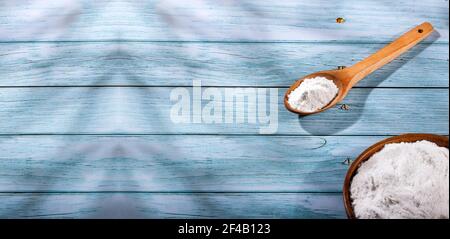 Backpulver in Glasschale und Holzlöffel Stockfoto