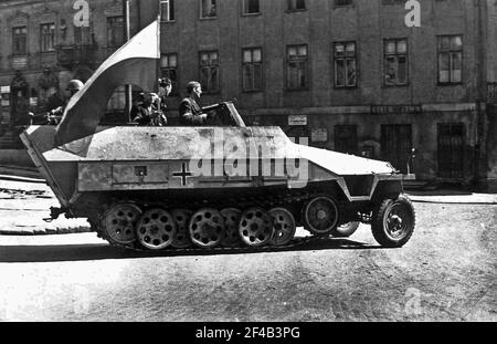 WarschauAufstand: Deutscher Panzerkämpfer SdKfz. 251, der von den polnischen Aufständischen vom 8. Krybar-Regiment am 14. August 1944 auf dem Na Skarpie-Boulevard von der 5. SS-Viking-Division gefangen genommen wurde. In diesem Bild auf der Tamka Straße, Soldat mit MP-40 Maschinenpistole ist sein erster aufständischer Kommandant Adam Dewicz 'Grey Wolf' Stockfoto