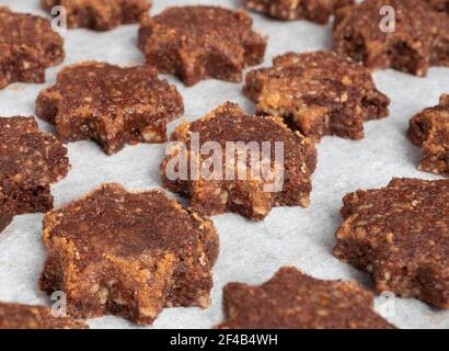 Reihen von glutenfreiem Mandelmehl und Schokoladenkekse in Form eines Sterns mit Zucker Zimt Rand, fertig zum Backen. Schweizer Rezept 'Basler Brunsli'. GF Stockfoto