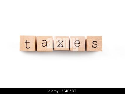 Steuern auf texturierten Holzblock Buchstaben geschrieben. Konzept für persönliche oder geschäftliche Steuern, Finanzamt oder Einreichung Steuer Saison. Isoliert auf Weiß. Stockfoto