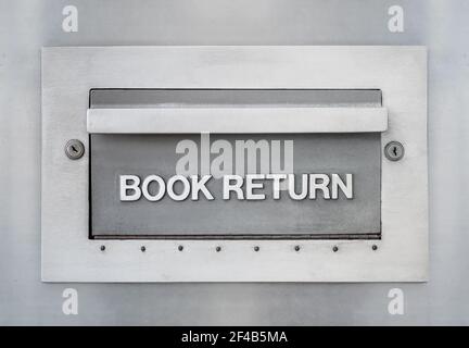 Ablagefach für Bücherrückgabe im Freien aus der Bibliothek. Große Metallschublade oder -Öffnung mit geprägtem Schriftzug „Book return“ mit Schlüsselschlössern für Diebstahlsicherung und Sicherheit Stockfoto