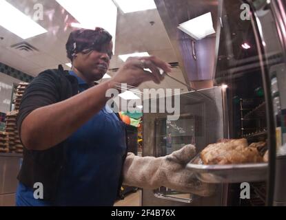 Danielle Robinson mit einem Thermometer die Temperatur der Hühner Braten im Ofen bei Nottingham Volksschule in Arlington, VA zu überprüfen, am Mittwoch, dem 12. Oktober 2011. Stockfoto