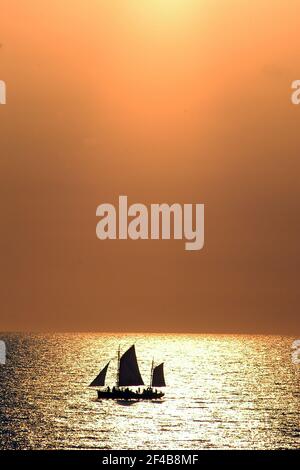 Broome ist eine Küstenstadt, Perlstadt und Touristenstadt in der Kimberley-Region von Western Australia. Foto zeigt Cable Beach bei Sonnenuntergang und ein Segelboot. Stockfoto