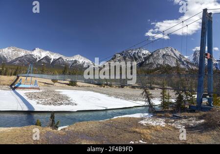 Fußgängerbrücke North Saskatchewan River. Skyline Der Schneebedeckten Berggipfel. Frühlingswanderung Kootenay Plains Ecological Reserve Landscape Stockfoto