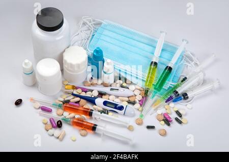 Masken, Spritze, Sortiment von verschiedenen Pillen und medizinische Flaschen. Konzept von Krankheit und Behandlung. Medizin und Gesundheitswesen. Stockfoto
