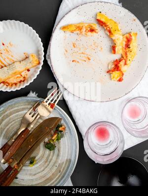 Stapel leerer und schmutziger Teller mit Essensresten auf dunklem Hintergrund. Draufsicht Stockfoto