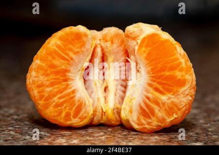 Süße geschälte Mandarine auf schwarzem Hintergrund. Stockfoto