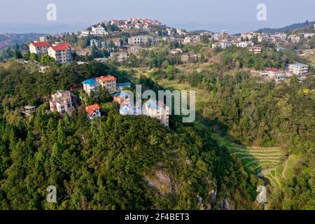 (210320) -- FUZHOU, 20. März 2021 (Xinhua) -- Luftfoto vom 16. März 2021 zeigt ein von Wäldern umgebenes Wohngebiet in Fuzhou, südöstlich der Provinz Fujian in China. Umgeben von Hügeln und Bergen auf drei Seiten, ist die Küstenstadt Fuzhou die Hauptstadt der Provinz Fujian, südöstlich von China. Mit ihrem reichen kulturellen und historischen Erbe ist die Hauptstadt mit ihrem Spitznamen Banyan City beliebter, da zahlreiche banyan-Bäume in der ganzen Stadt gepflanzt werden und den Bürgern entlang der Straßen und Straßen Schatten spenden. Mit dem Minjiang Fluss, der durch die Stadt fließt, genießt Fuzhou einen Favoriten Stockfoto