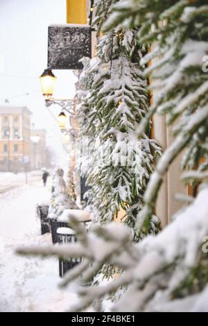 Aleksanterinkatu Straße während des starken Schneesturms. Fenster mit schneebedeckten Fichtenzweigen. Die schöne weihnachtliche Atmosphäre in Helsin Stockfoto