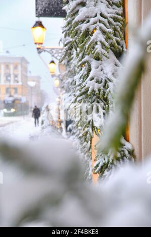 Aleksanterinkatu Straße während des starken Schneesturms. Fenster mit schneebedeckten Fichtenzweigen. Die schöne weihnachtliche Atmosphäre in Helsin Stockfoto