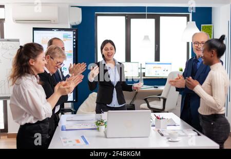 Fröhliche, vielfältige Mitarbeiter applaudieren nach erfolgreicher Präsentation. Multiethnical Partner Coworker feiern erfolgreiche Teamarbeit Ergebnis bei der Unternehmens-Briefing Stockfoto