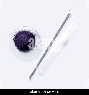 Kosmetische Chemikalien Inhaltsstoff auf weißem Labortisch. Kaliumpermanganat (KMnO4), Rührstab und Reagenzglas. Stockfoto