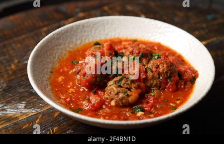 Fleischbällchen in Tomatensauce mit einer Prise Petersilie gekocht In einem traditionellen Pub und Restaurant Stockfoto
