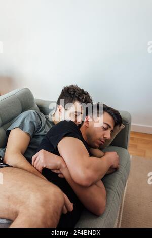Ein junges kaukasisches Gay-Paar schlafen in der Couch und Sich umarmen Stockfoto