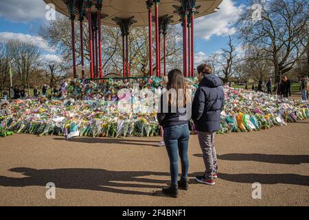 LONDON, ENGLAND - MÄRZ 19: Ein Paar schaut sich die floralen Tribute an, die am 19 2021. März in London, Großbritannien, am Bandstand auf Clapham Common hinterlassen wurden. © Hor