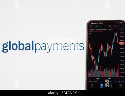 In dieser Abbildung werden die Börseninformationen von Global Payments Inc. Auf einem Smartphone mit dem Logo von Global Payments Inc. Im Hintergrund angezeigt. Stockfoto