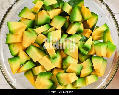 Gelbgrüne Avocado Zellstoff in Glasschüssel zu kleinen Stücken geschnitten, Ansicht von oben Stockfoto