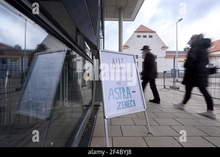 Dresden, Deutschland. März 2021, 20th. Ein Mann und eine Frau gehen an einem Schild mit der Aufschrift "Alle Erstimpfungen mit AstraZeneca" im Impfzentrum der Messe Dresden vorbei. Das Land Sachsen nimmt die Impfungen mit dem Impfstoff AstraZeneca wieder auf. Impfungen mit dem Impfstoff AstraZeneca waren am 15. März 2021 kurz gestoppt worden, nachdem Blutgerinnsel im zeitlichen Zusammenhang mit Impfungen aufgetreten waren. Quelle: Robert Michael/dpa-Zentralbild/dpa/Alamy Live News Stockfoto
