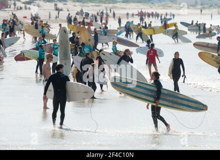 Menge von Surfern am Muizenberg Strand tragen Surfbretter Konzept beliebten Wassersport in Kapstadt, Südafrika Stockfoto