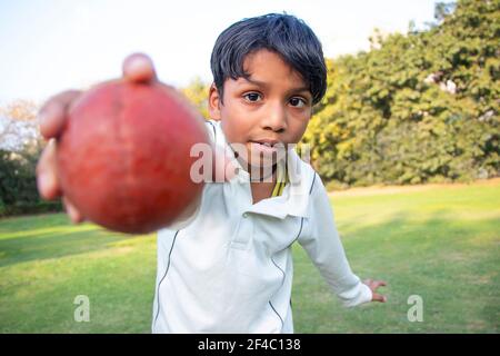 Kleiner Junge Bowling Bein Spin in einem Cricket Stockfoto