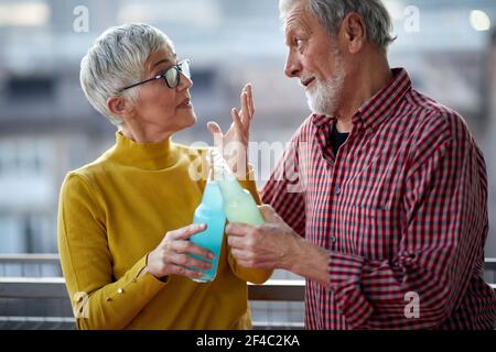 Ein älteres Paar plaudert und genießt einen Drink in einer entspannten Atmosphäre auf der Terrasse bei schönem Sonnenuntergang über der Stadt. Beziehung, Liebe, zusammen Stockfoto