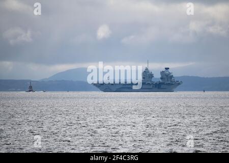 Cove, Argyle und Bute, Schottland, Großbritannien. März 2021, 20th. IM BILD: Schlepper manövrieren HMS Queen Elizabeth, während sie in den Firth of Clyde segelt. Die Leute beobachten, wie die HMS Queen Elizabeth nach fast einer Woche in Loch Long in Glenmallan, wo sie Treibstoff, Munition und andere Vorräte annahm, vor den Marineübungen, die Teil der britischen Carrier Strike Group 2021 sind, die Segel setzte. Quelle: Colin Fisher/Alamy Live News Stockfoto