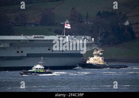 Cove, Argyle und Bute, Schottland, Großbritannien. März 2021, 20th. IM BILD: Schlepper manövrieren HMS Queen Elizabeth, während sie in den Firth of Clyde segelt. Die Leute beobachten, wie die HMS Queen Elizabeth nach fast einer Woche in Loch Long in Glenmallan, wo sie Treibstoff, Munition und andere Vorräte annahm, vor den Marineübungen, die Teil der britischen Carrier Strike Group 2021 sind, die Segel setzte. Quelle: Colin Fisher/Alamy Live News Stockfoto