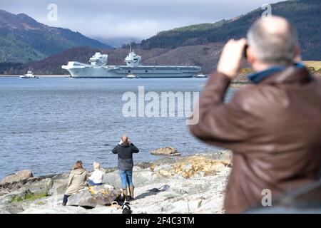 Cove, Argyle und Bute, Schottland, Großbritannien. März 2021, 20th. IM BILD: Die Menschen fotografieren die HMS Queen Elizabeth, die in den Firth of Clyde segelt. Die Leute beobachten, wie die HMS Queen Elizabeth nach fast einer Woche in Loch Long in Glenmallan, wo sie Treibstoff, Munition und andere Vorräte annahm, vor den Marineübungen, die Teil der britischen Carrier Strike Group 2021 sind, die Segel setzte. Quelle: Colin Fisher/Alamy Live News Stockfoto