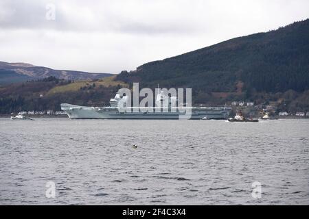 Cove, Argyle und Bute, Schottland, Großbritannien. März 2021, 20th. IM BILD: Die Leute schauen, wie die HMS Queen Elizabeth nach fast einer Woche in Loch Long in Glenmallan, wo sie Treibstoff, Munition und andere Vorräte annahm, vor den Marineübungen, die Teil der britischen Carrier Strike Group 2021 sind, die Segel setzte. Quelle: Colin Fisher/Alamy Live News Stockfoto