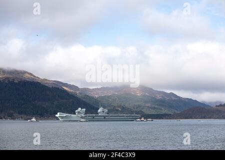 Cove, Argyle und Bute, Schottland, Großbritannien. März 2021, 20th. IM BILD: Die Leute schauen, wie die HMS Queen Elizabeth nach fast einer Woche in Loch Long in Glenmallan, wo sie Treibstoff, Munition und andere Vorräte annahm, vor den Marineübungen, die Teil der britischen Carrier Strike Group 2021 sind, die Segel setzte. Quelle: Colin Fisher/Alamy Live News Stockfoto