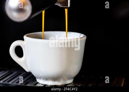 Eine Nahaufnahme einer Tasse heißen Kaffee zubereitet In einer Kaffeemaschine Stockfoto